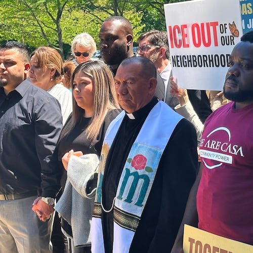 Kilmar Abrego Garcia and his wife, center, hold hands as people rally in support of him at a news conference outside federal court after a hearing in his case on Tuesday, May 12, 2026, in Greenbelt, Md. (AP Photo/Michael Kunzelman)
