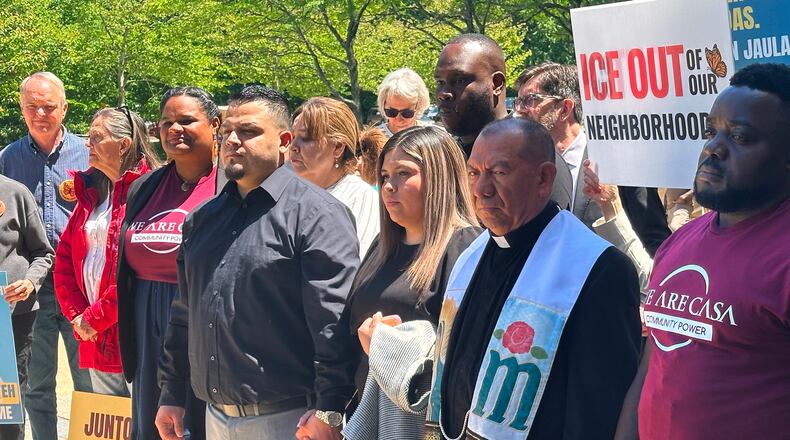 Kilmar Abrego Garcia and his wife, center, hold hands as people rally in support of him at a news conference outside federal court after a hearing in his case on Tuesday, May 12, 2026, in Greenbelt, Md. (AP Photo/Michael Kunzelman)