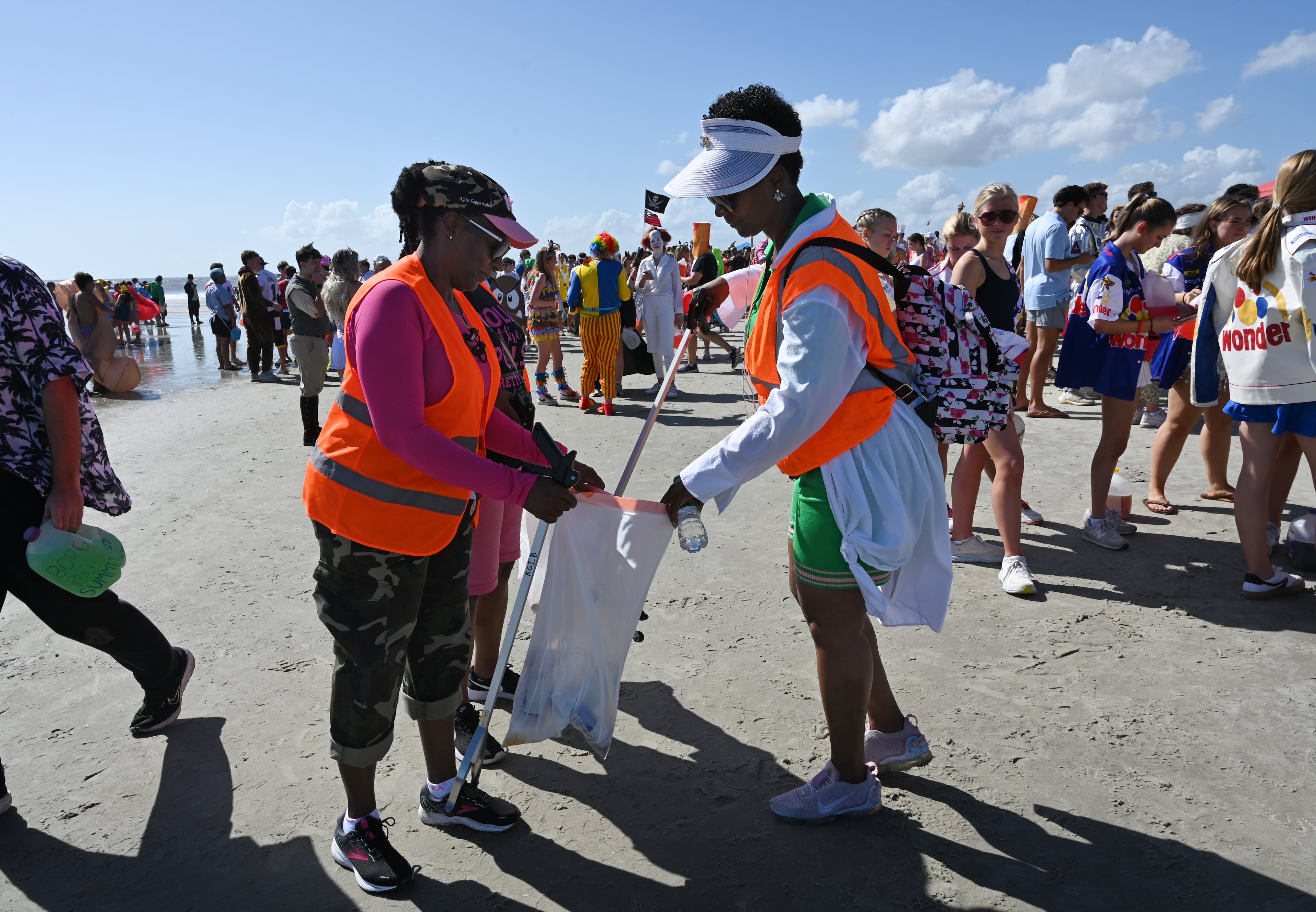 Local volunteers including Felicity Littles (right) pick up trashes during the annual “Frat Beach” party for the weekend of the Georgia-Florida football game on St. Simons Island, Friday, November 1, 2024. On the weekend of the Georgia-Florida football game, St. Simons Island’s East Beach becomes “Frat Beach,” an open-air party teeming with thousands of college students. (Hyosub Shin / AJC)