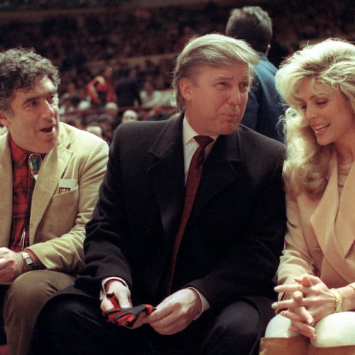 FILE - Actor Elliott Gould, left, joins Donald Trump, center, and Marla Maples at courtside during an NBA basketball game between the Phoenix Suns and the New York Knicks at Madison Square Garden, in New York, March 6, 1991. (AP Photo/Steve Freeman, File)