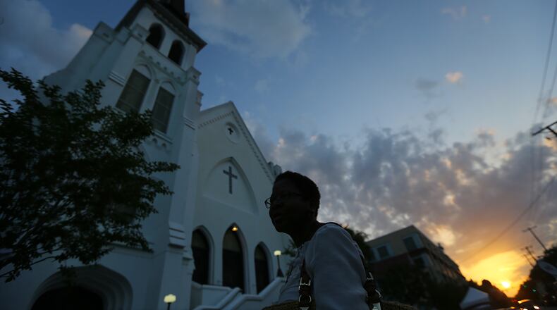 Gillettie Bennett, a local school teacher, is the first in line at sunrise at the "Mother" Emanuel AME Church waiting for it to open four days after the mass shooting that claimed the lives of its pastor and eight others on Sunday, June 21, 2015, in Charleston. Bennett said she was attending the service because it represented the resilience of the Charleston people. Curtis Compton / ccompton@ajc.com