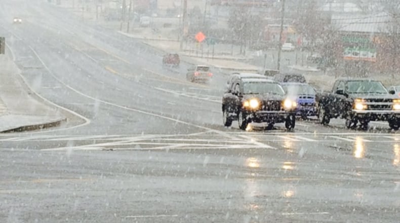 The Big Chicken is barely visible as snow falls late Wednesday afternoon on Cobb Parkway. (CHRISTIAN BOONE / CBOONE@AJC.COM)