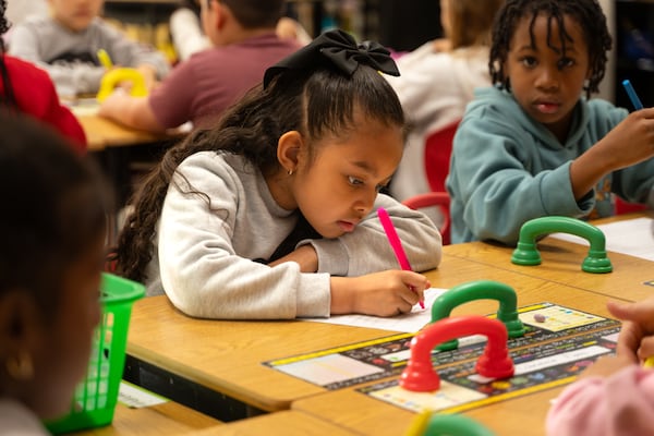 First graders at Vickery Mill Elementary in Roswell work on identifying words with the same letter patterns on Thursday, March 5, 2026. When they finish, they pick up a colorful “whisper phone” and read the words into the phone. (Ben Hendren for the AJC)