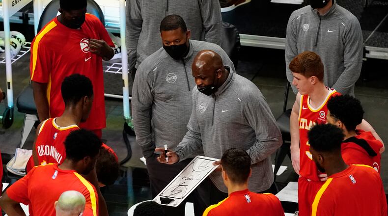 Atlanta Hawks head coach Nate McMillan, center, draws a play before the start of the second half of an NBA basketball game after the game Wednesday, April 7, 2021, in Atlanta. (AP Photo/John Bazemore)