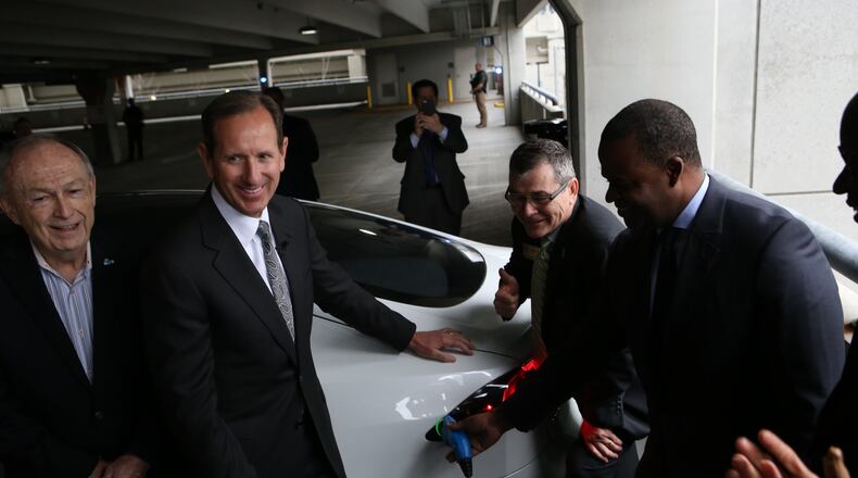 From left, Don Francis, of Clean Cities Georgia; Paul Bowers, CEO of Georgia Power; Tim Echols, of the Georgia Public Service Commission; and Atlanta Mayor Kasim Reed after plugging in a vehicle at a new charging station at the Atlanta airpiort’s international terminal. (HENRY TAYLOR / HENRY.TAYLOR@AJC.COM)