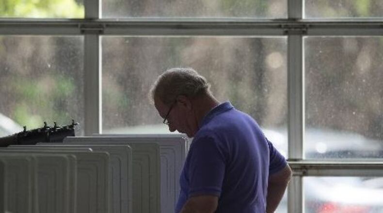 Alpharetta resident Rory McCarthy casts his ballot at Alpharetta Fire Station 82 Tuesday. (DAVID BARNES / DAVID.BARNES@AJC.COM)