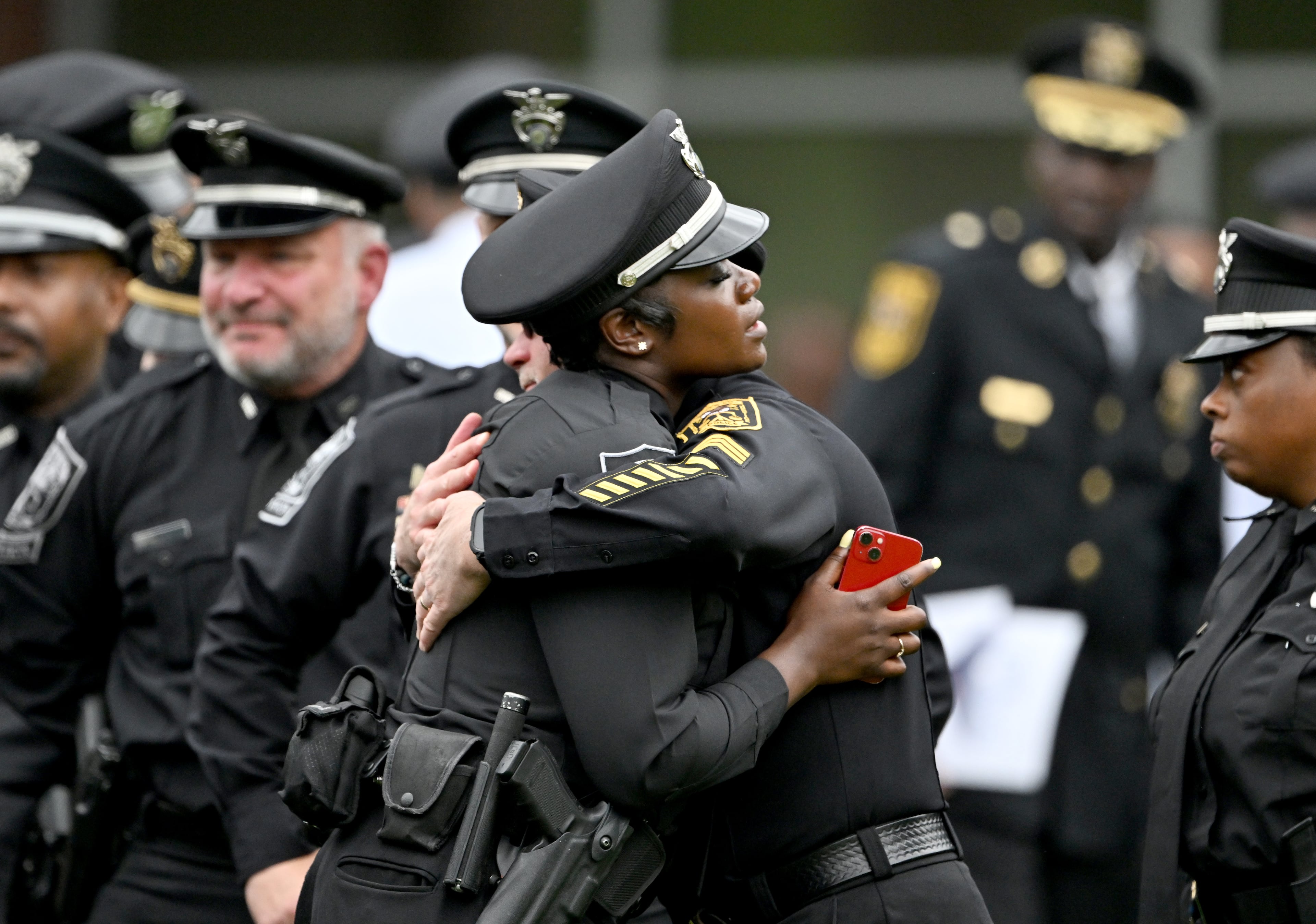 Members of DeKalb County police embrace during the Final Honors following the memorial service for DeKalb County police Officer David Rose, who was killed while responding to the Aug. 8 shooting at the CDC, outside the First Baptist Church Atlanta, Friday, August 22, 2025, in Atlanta. Hyosub Shin / AJC)