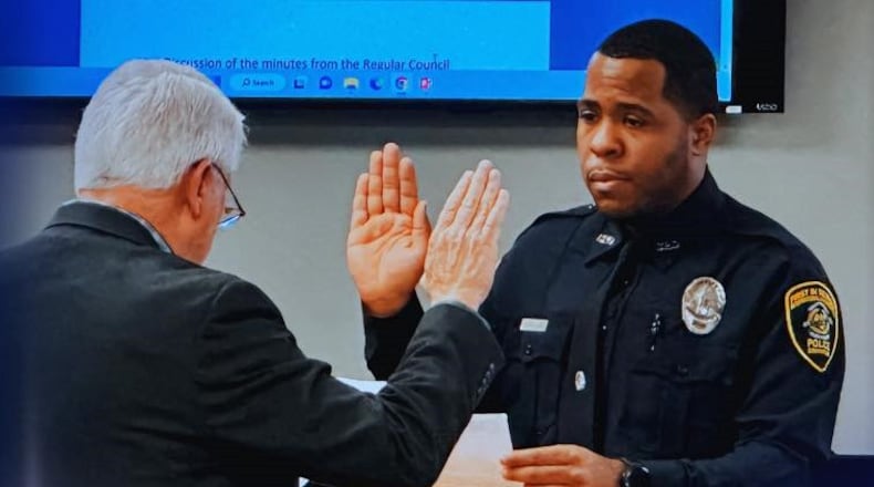 Rashad Rivers (right) is sworn in as an officer of the Covington Police Department in a January ceremony. He was wounded in a shooting Tuesday night at a motel.