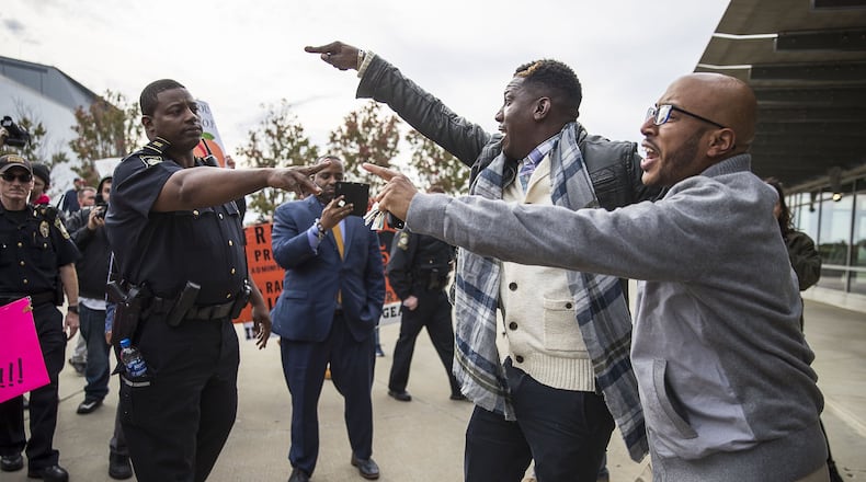 A Georgia World Congress police officer separates President Donald Trump supporters Tony Smith (right) of College Park and Jerrod Brown (center) of Savannah, from a crowd of anti-Trump protestors outside of the Georgia World Congress Center, Friday, November 8, 2019. President Trump was in Atlanta on Friday to speak to a crowd of African American voters that support his presidency. (Alyssa Pointer/Atlanta Journal Constitution)
