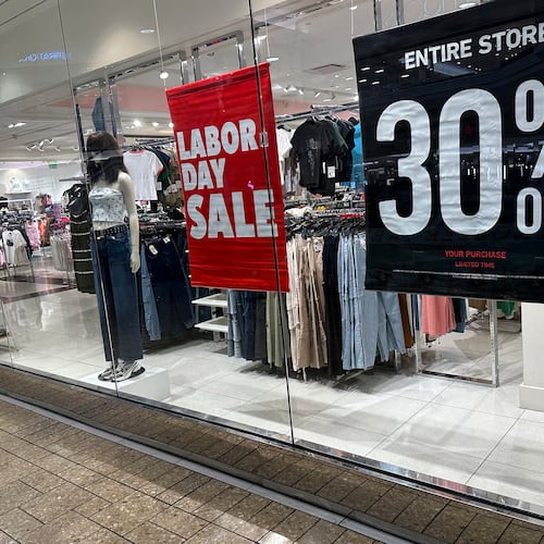 FILE - Signs announce a Labor Day sale in the window of a clothing store at a mall in Denver on Aug. 21, 2024. (AP Photo/David Zalubowski, File)