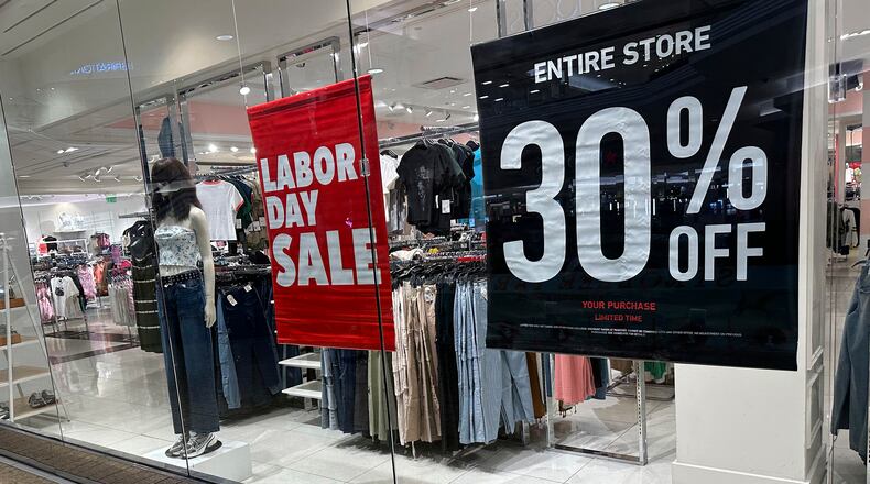 FILE - Signs announce a Labor Day sale in the window of a clothing store at a mall in Denver on Aug. 21, 2024. (AP Photo/David Zalubowski, File)