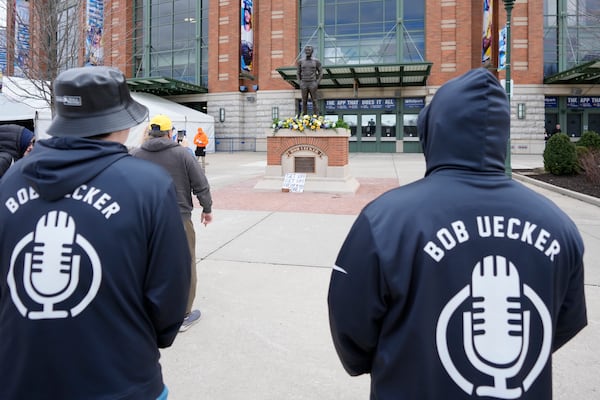 Sean Woods, left, and David Woods observe the memorial at the Bob Uecker statue in front of American Family Field prior to a baseball game between the Milwaukee Brewers and the Kansas City Royals on Opening Day Monday, March 31, 2025, in Milwaukee. (AP Photo/Kayla Wolf)