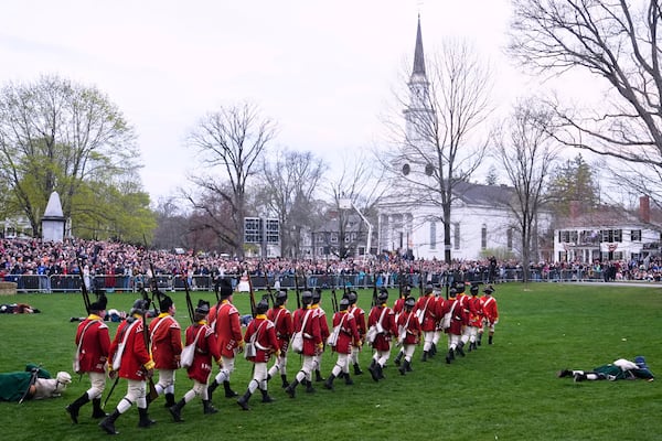 British Regulars march past fallen New England colonial militia, also known as a Minuteman, during a reenactment celebration of the 250th anniversary of the Battle of Lexington and start of the American Revolution, Saturday, April 19, 2025, in Lexington, Mass. (AP Photo/Charles Krupa)