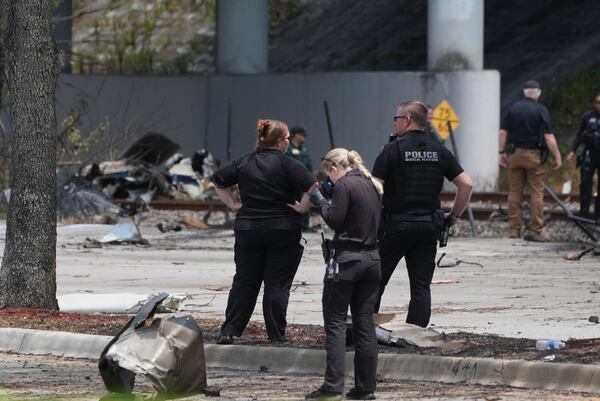 Emergency personnel respond to the area where a small plane crashed on the railroad tracks beneath the overpass near Interstate 95 in Boca Raton, Fla., on Friday, April 11, 2025. (AP Photo/Marta Lavandier)