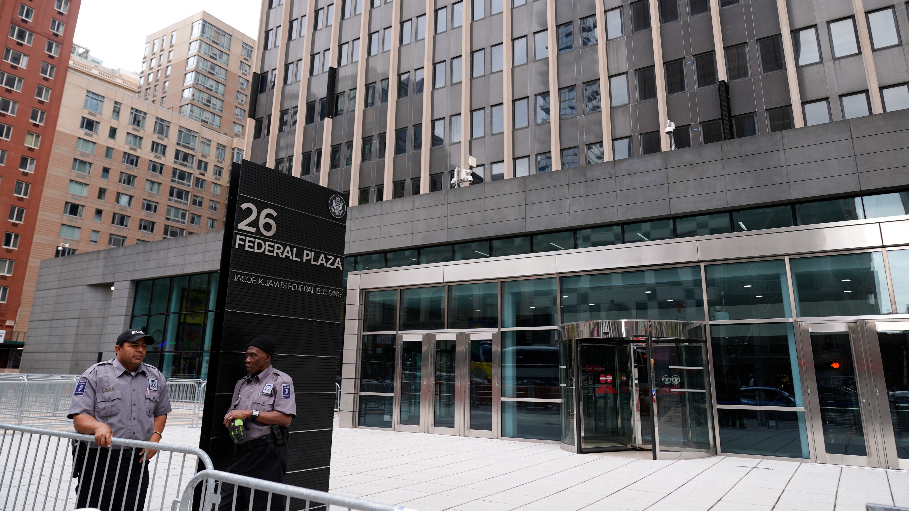 FILE - Security guards stand outside the Jacob K. Javits Federal Office Building at 26 Federal Plaza, Monday, Sept. 30, 2024, in New York. (AP Photo/Pamela Smith, file)