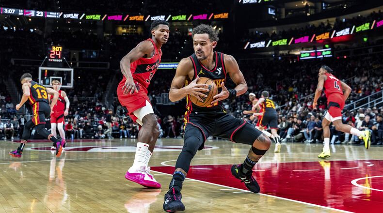 Trae Young secures a loose ball after a missed shot in Friday's Hawks-Raptors game at State Farm Arena.