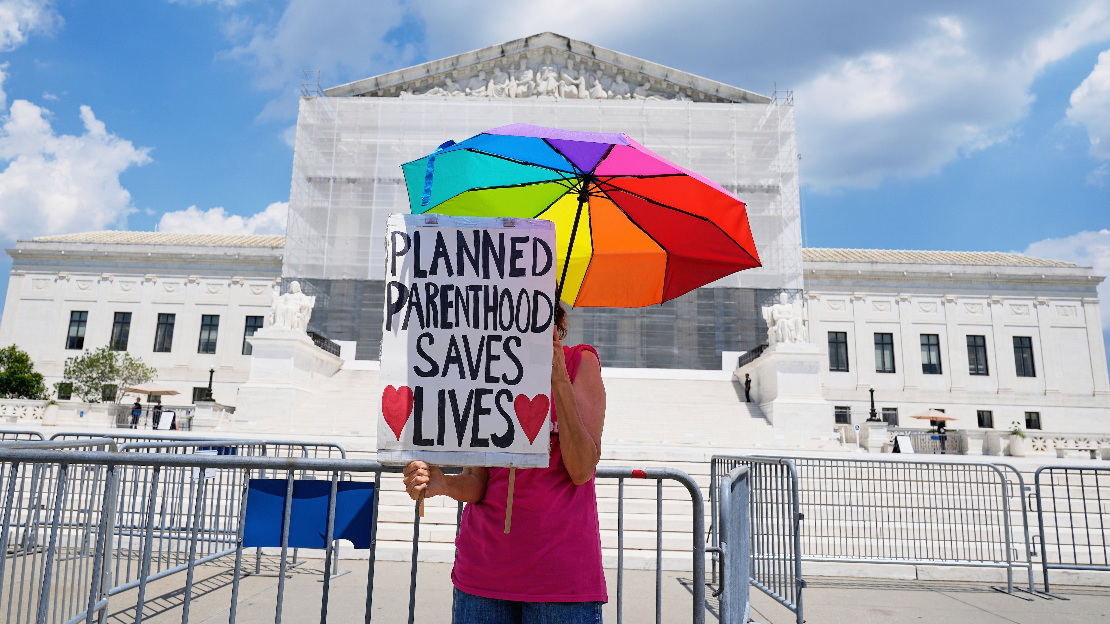 FILE - A protester stands outside of the Supreme Court, June 26, 2025, in Washington. (AP Photo/Mariam Zuhaib, File)
