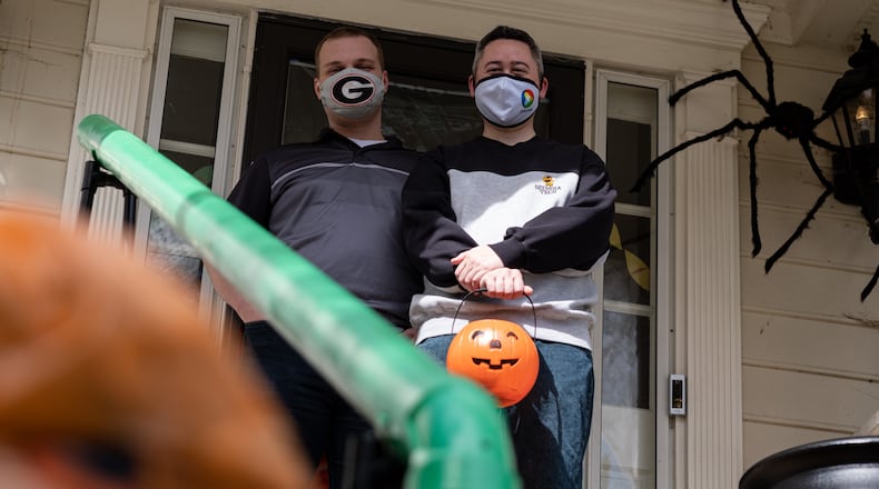 201016-Atlanta-Heath Hall, left, and Ben Ku aren’t sure how many trick-or-treaters they will get this year at their Tucker home, so they built a chute to deliver candy while keeping socially distanced on Halloween. Ben Gray for the Atlanta Journal-Constitution