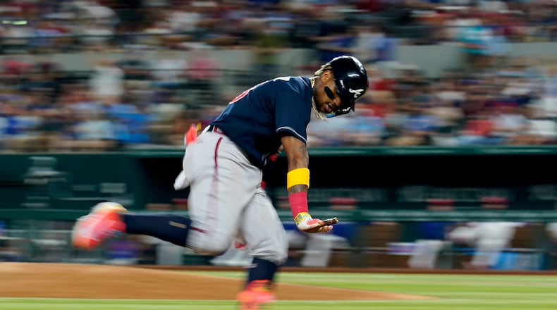 The Braves' Ronald Acuna Jr. gestures to the dugout after hitting a solo home run against the Texas Rangers during the sixth inning of a baseball game Wednesday, May 17, 2023, in Arlington, Texas. (AP Photo/Tony Gutierrez)