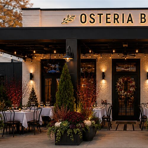 The exterior of a modern Italian restaurant called Osteria Bella at dusk.