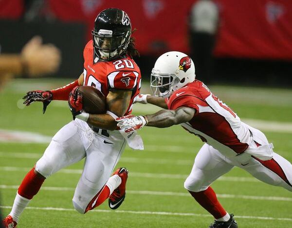 Falcons safety Dwight Lowery intercepts Cardinals Drew Stanton getting past wide receiver Jaron Brown for more yardage during the first quarter in an NFL football game on Sunday, Nov. 30, 2014, in Atlanta. CURTIS COMPTON / CCOMPTON@AJC.COM