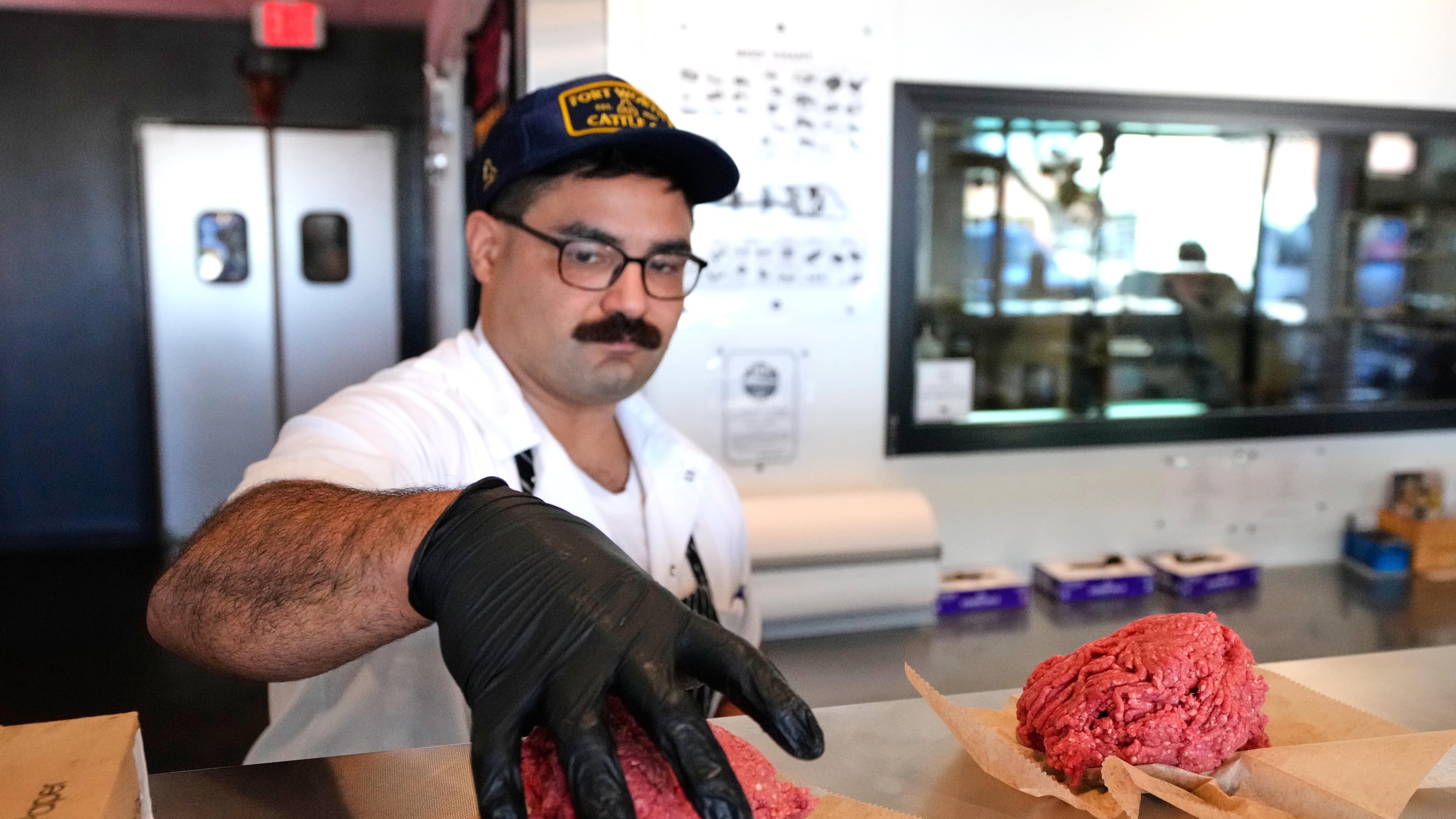 Nate Abeyta, owner and founder of Deep Cuts butcher shop prepares an order of ground meat for a customer, Tuesday, Oct. 21, 2025, in Dallas. (AP Photo/Tony Gutierrez)