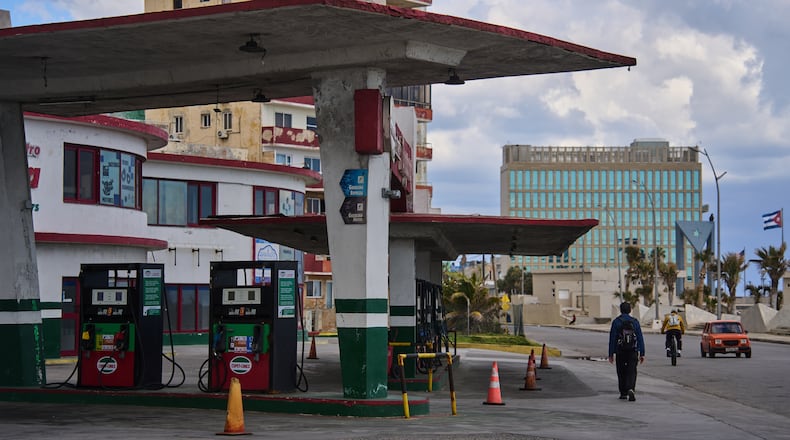 FILE - A man walks past a gas station that has run out of fuel, located near the U.S Embassy, pictured in the background, in Havana, Cuba, Feb. 7, 2026. (AP Photo/Ramon Espinosa, File)