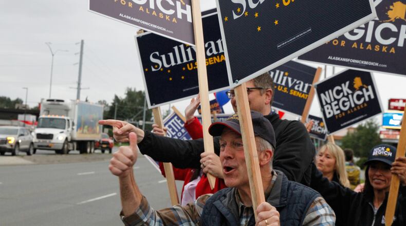 Sen. Dan Sullivan, R-Alaska, who is seeking a third term, flashes a thumbs up after a passing motorist honked during a sign waving event at an intersection on primary election day in Anchorage, Alaska, Tuesday, Aug. 18, 2026. (AP Photo/Mark Thiessen)