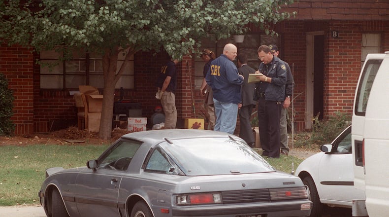 OCTOBER 1997: Officials from the GBI and the Atlanta Police Department investigate the scene where Officer John “Rick” Sowa was murdered, and his partner Officer Pat Cocciolone was wounded, on Oct. 12, 1997. (Kimberly Smith/ AJC file photo)