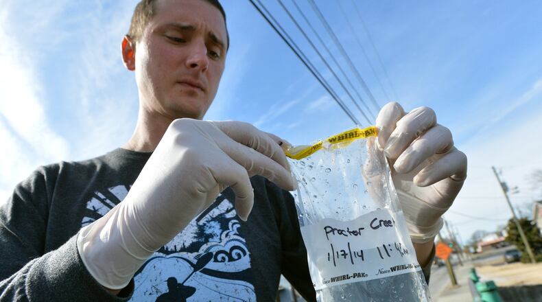 Jason Ulseth, technical programs director of Chattahoochee Riverkeeper, seals the water sample from Proctor Creek off Joseph E Boone Blvd in Atlanta on Friday, January 17, 2014. Under a federal order, Atlanta water officials spent millions to untangle portions of the city’s water and sewer connections to stop raw sewage from flowing into Proctor Creek.