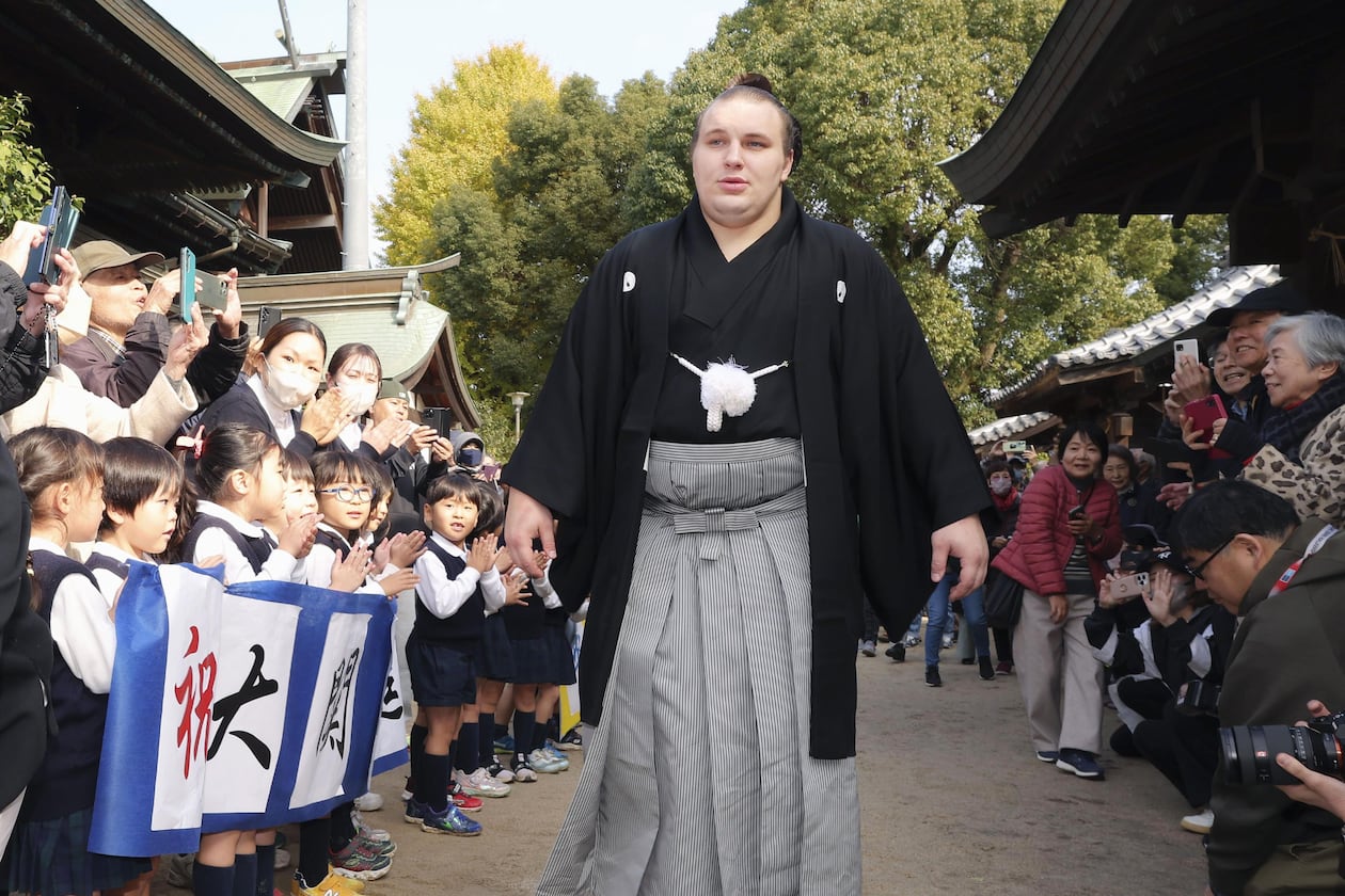 Ukrainian sumo wrestler Aonishiki, center, is celebrated by kindergarteners his promotion to the rank of ozeki in Kurume, Fukuoka prefecture, southern Japan Wednesday, Nov. 26, 2025. (Kyodo News via AP)