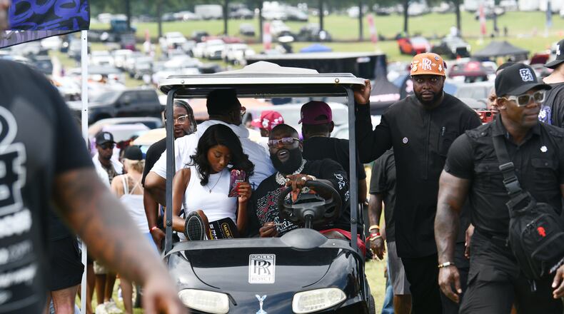 Rick Ross drives his golf cart around the Rick Ross Car Show on Saturday at the Promise Land, his mansion in Fayetteville. The car show included a market with more than 30 vendors, food trucks, fleets of classic/custom automobiles, luxury vehicles, boats, RVs and trailers on the front lawn of the mansion. There were also performances by Plies, Ross' new signee, Nino Breeze, and Ross himself. (Hyosub Shin/AJC)