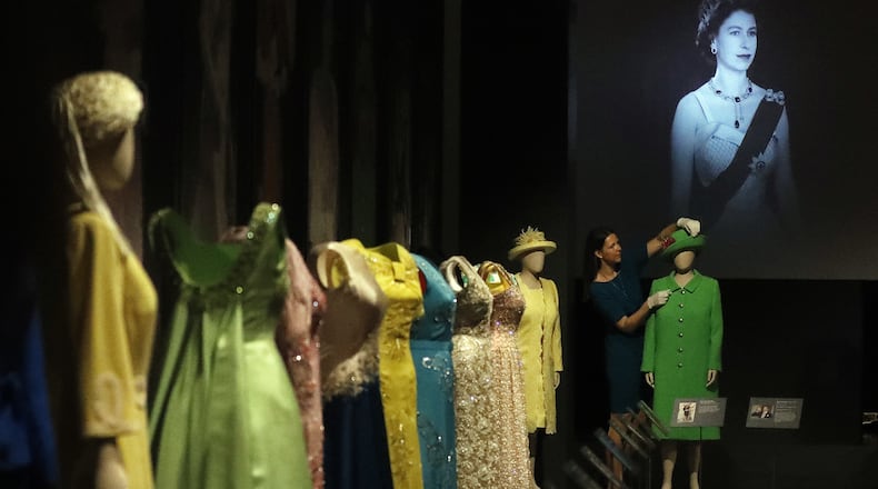 A woman adjusts dresses of Britain’s Queen Elizabeth at an exhibition at Buckingham Palace in London, Thursday, July 21, 2016. In celebration of Her Majesty’s 90th birthday this year, visitors to the Summer Opening of the State Rooms at Buckingham Palace will enjoy an unprecedented display of The Queen’s outfits, from childhood to the present day, in the special exhibition Fashioning a Reign: 90 Years of Style from The Queen’s Wardrobe. (AP Photo/Frank Augstein)