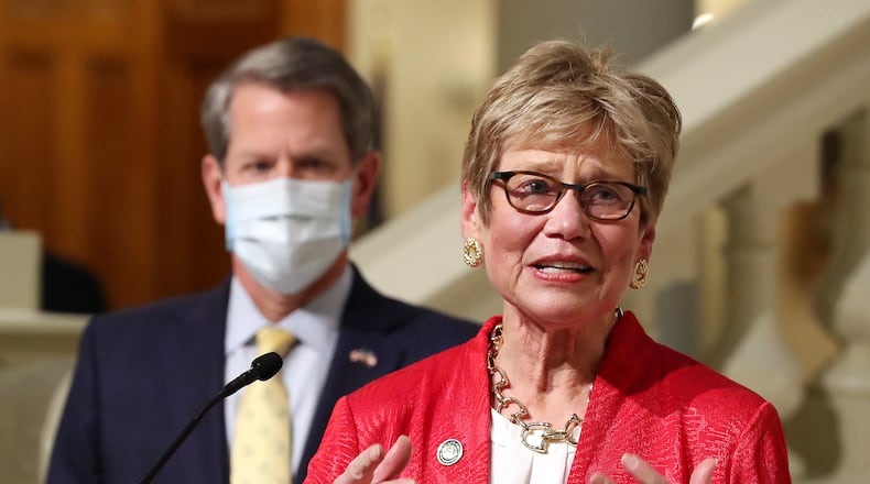 Dr. Kathleen Toomey, Georgia's public health commissioner, speaks about the coronavirus pandemic during a 2021 press conference as her boss, Gov. Brian Kemp, watches. Toomey fired the top lawyer at the Department of Public Health, who has won a $750,000 settlement from the state over her termination. Curtis Compton / Curtis.Compton@ajc.com”