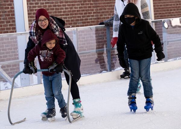 Ryma Hamek helps Luis Rodriguez, 5, make his way around the Have an Ice Day rink in downtown Sugar Hill on Saturday afternoon, December 26, 2020. (Photo: Ben Gray for The Atlanta Journal-Constitution)