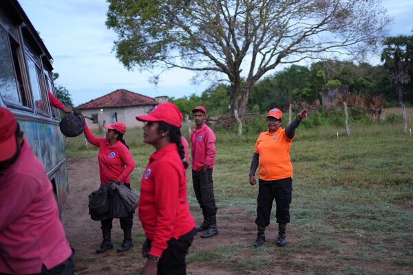 Thavarathnam Pushparani, right, directs her team members as they prepare to work in a contaminated mining area in Mankulam, Sri Lanka, Thursday, April 3, 2025. (AP Photo/Eranga Jayawardena)