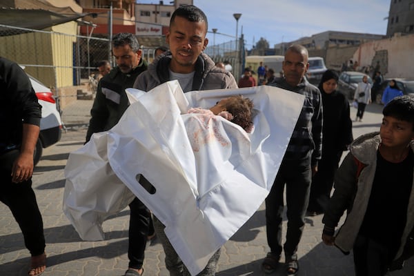 Hosam Seiam carries the body of his niece Ahlam Seiam, who was just days away from her first birthday, into Nasser Hospital, after their home was hit by an overnight Israeli airstrike in Khan Younis, southern Gaza Strip, on Wednesday, April 16, 2025.(AP Photo/Mariam Dagga)