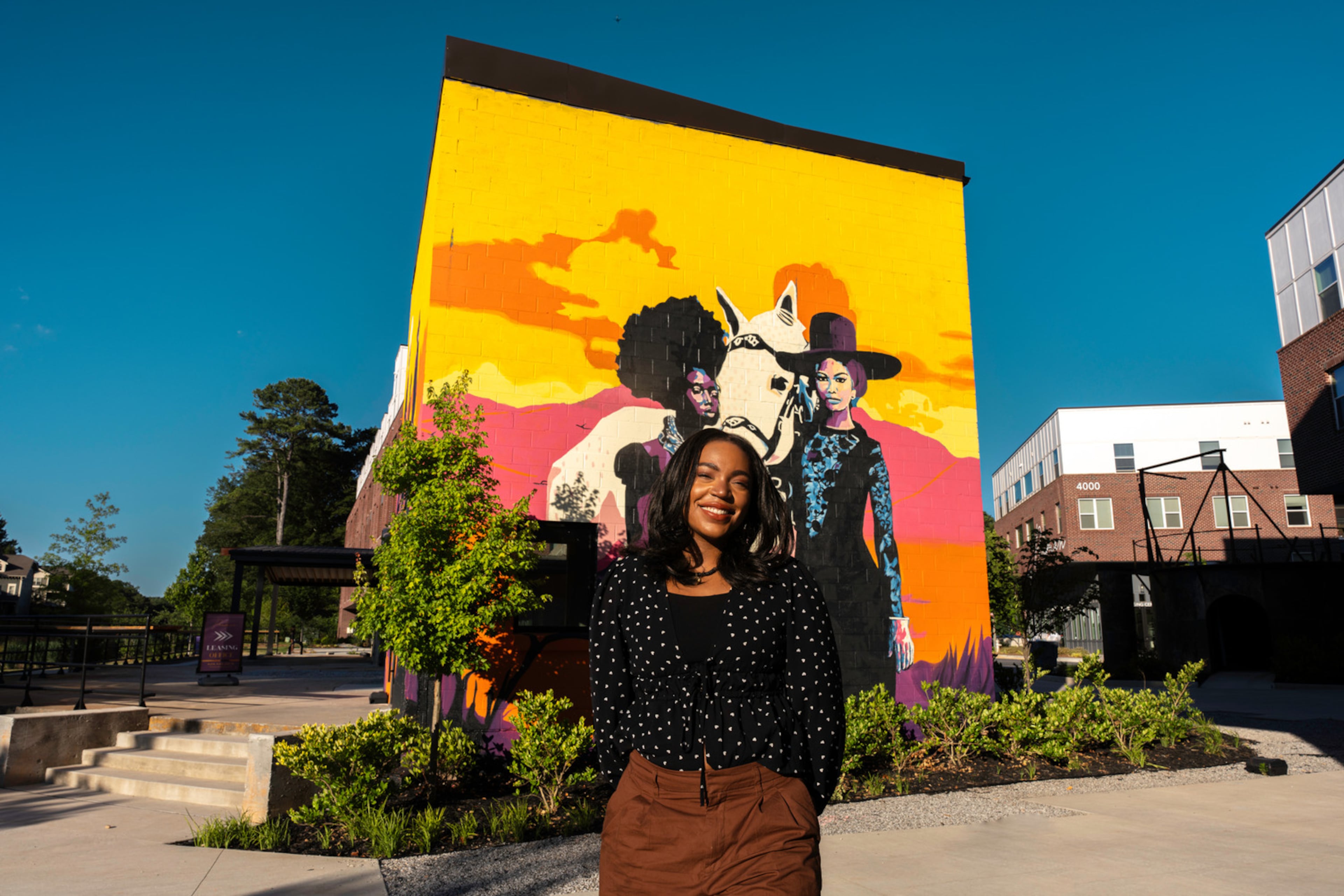 Aziza Andre in front of her mural “Renascent" in Atlanta.