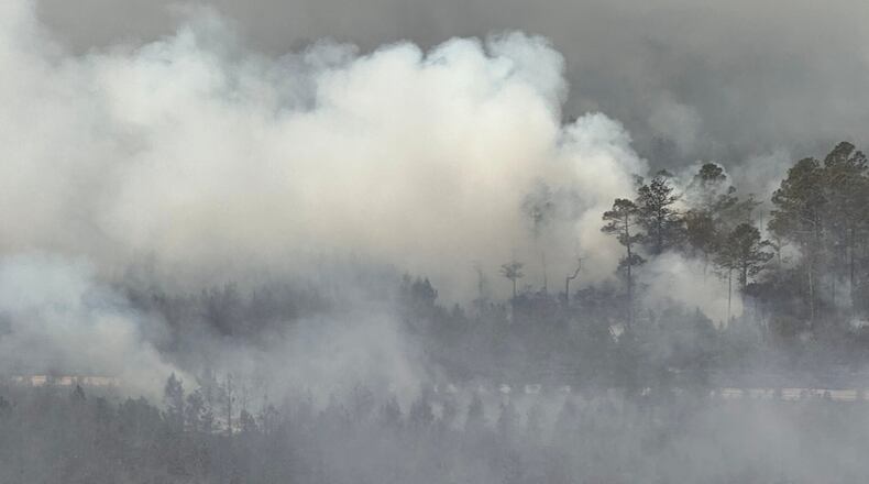 The photo provided by the Office of Gov. Brian Kemp shows smoke produced by a wildfire in Brantley County, Ga., Friday, April 24, 2026. (Office of Gov. Brian Kemp via AP)
