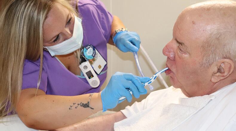 James Massie, an Army veteran and a patient at the Salem Veterans Affairs Medical Center in Salem, Virginia, gets his teeth brushed by nursing assistant Teresa Quarles in June. (Rosaire Bushey/KHN/TNS)