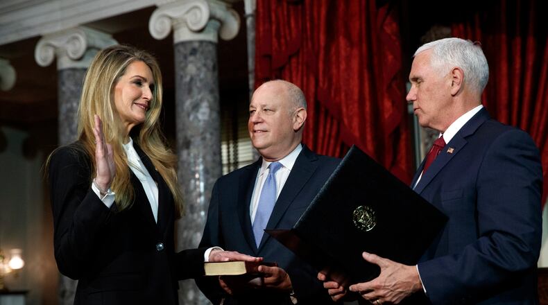 Sen. Kelly Loeffler, R-Ga., left, with her husband Jeffrey Sprecher, center, participates in a re-enactment of her swearing-in Monday Jan. 6, 2020, by Vice President Mike Pence in the Old Senate Chamber on Capitol Hill in Washington. (AP Photo/Jacquelyn Martin)