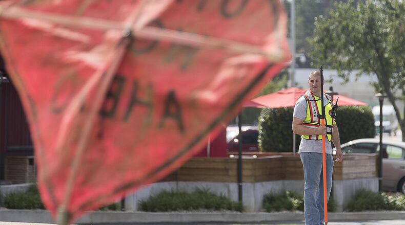 6/19/2019 — Marietta, Georgia — An undercover Marietta Police officer stands in a median looking for distracted drivers along US 41 during a multi-agency distracted driving enforcement operation in Marietta, Wednesday, June 19, 2019. The operation, which involved three under-cover Marietta Police officers dressed as construction workers, took place at the intersection of US 41 and Roswell Road. When the officers saw a distracted driving violation, in addition to others, they radioed ahead and one of the forty officers involved in the operation issued a citation to the driver. (Alyssa Pointer/alyssa.pointer@ajc.com)