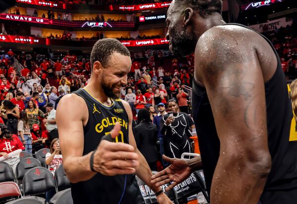 Golden State Warriors' Stephen Curry (30) celebrates with Draymond Green (23) after Game 7 of an NBA basketball first-round playoff series against the Houston Rockets in Houston, Sunday, May 4, 2025. (Carlos Avila Gonzalez/San Francisco Chronicle via AP)