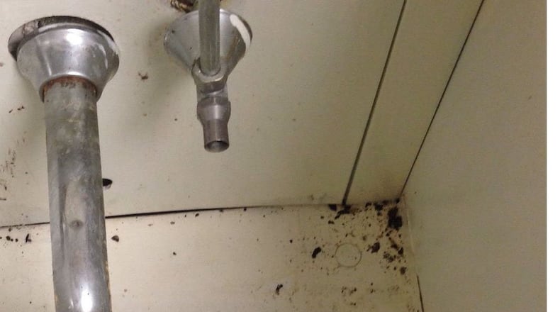 A roach and dirt are in the abandoned cabinet of a sink near the operating room at Augusta State Medical Prison. The sink was damaged by water when an air conditioning duct burst in mid-August.