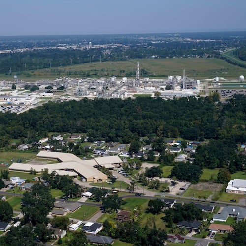 FILE - The Fifth Ward Elementary School and residential neighborhoods sit near the Denka Performance Elastomer Plant, back, in Reserve, La., Sept. 23, 2022. (AP Photo/Gerald Herbert, File)