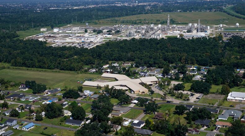 FILE - The Fifth Ward Elementary School and residential neighborhoods sit near the Denka Performance Elastomer Plant, back, in Reserve, La., Sept. 23, 2022. (AP Photo/Gerald Herbert, File)