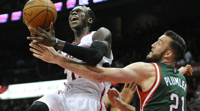 Milwaukee Bucks’ Miles Plumlee (21) fouls Atlanta Hawks’ Dennis Schroder, left, in the first half of an NBA basketball game Monday, March 30, 2015, in Atlanta. (AP Photo/David Tulis)
