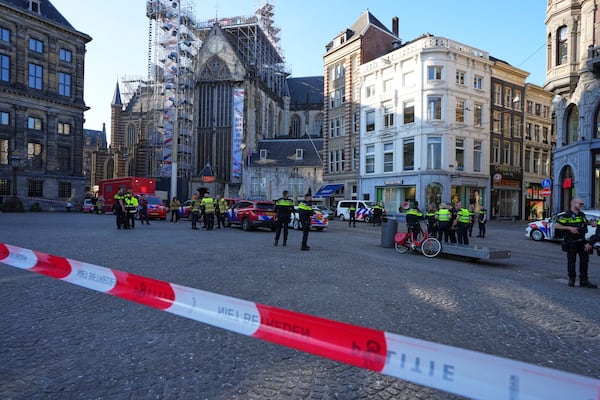 Police officers stand behind a cordoned off area after a stabbing near Dam Square in central Amsterdam, Thursday, March 27, 2025. (AP Photo/Peter Delong)