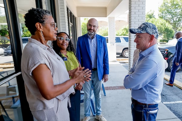 From left, Laundry Lounge owner Sherwin Clemons, Sandy Springs councilwoman Melody Kelley and Democratic nominee for lieutenant governor Josh McLaurin talk with U.S. Sen. Mark Kelly during a campaign stop in Sandy Springs on Wednesday, Aug. 19, 2026. (Erik S. Lesser for the AJC)