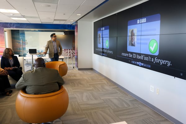 Georgia Technology Authority Chief Digital and Artificial Intelligence Officer Nikhil Deshpande, standing, shows a video about MyGeorgia to the AJC at the GTA, Monday, May 4, 2026, in Atlanta. (Jason Getz/AJC)